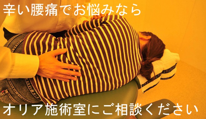 腰の施術を受けている女性の写真1｜桜通線
