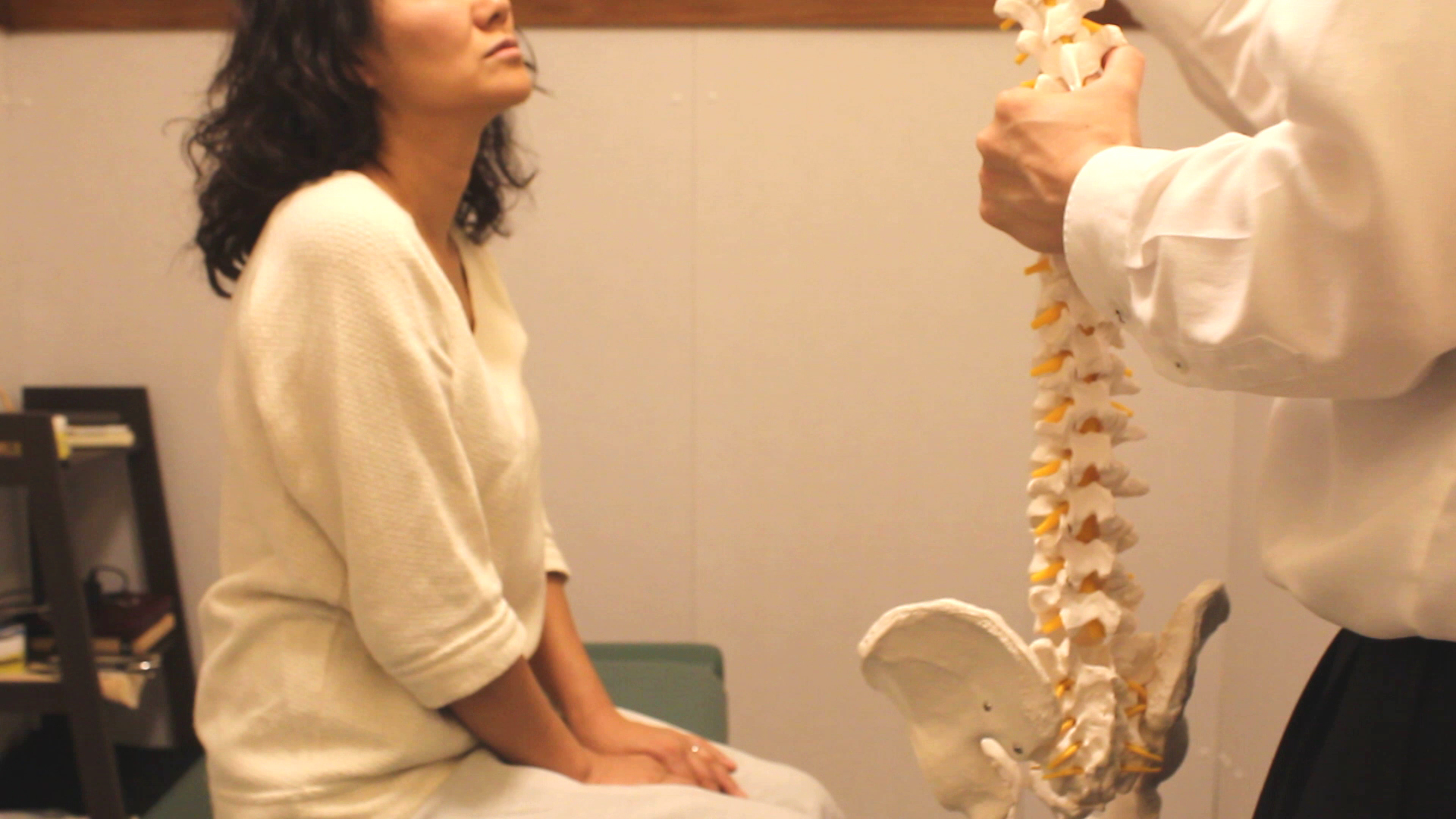 整体のオリア施術室にて背骨の説明を受ける女性の写真1
